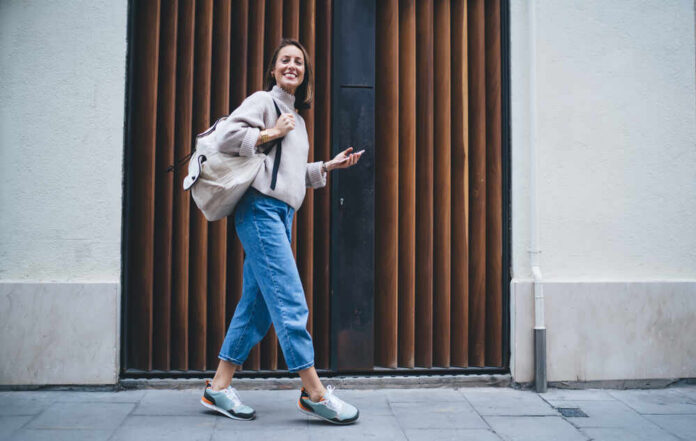 Full,Length,Portrait,Of,Cheerful,Girl,30s,Using,Digital,Cellphone