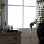 SuperAgers’ Brains Defy Aging Science Elderly man standing with a cane next to a table with flowers and medication