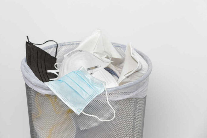 shutterstock2535671395jpg A trash bin filled with various discarded face masks