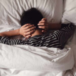Silk Masks: The Sleep Game-Changer Child lying in bed with hands over ears