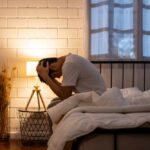 UCSF’s Bold Depression Breakthrough A person sitting on a bed with their head in their hands, expressing distress