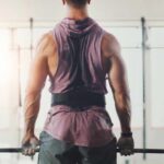 Muscle Growth: Overcoming Genetic Handicaps A muscular person preparing to lift a barbell in a gym setting