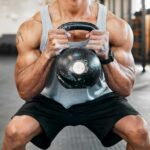 The Squat Secret Most Miss Athlete performing a kettlebell squat in a gym