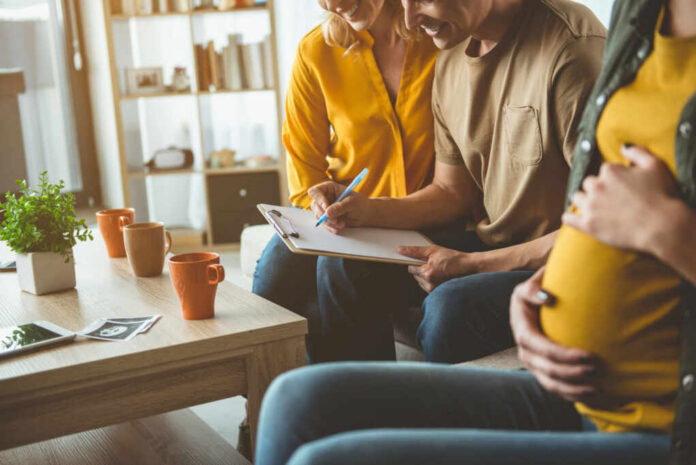 A couple and a friend discussing notes while seated in a cozy living room