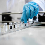 Revolutionary Cancer Treatment Slashes Costs A healthcare professional in a lab preparing vaccine vials