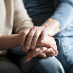 Close-up of two hands gently holding each other, symbolizing support and affection