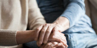 Close-up of two hands gently holding each other, symbolizing support and affection