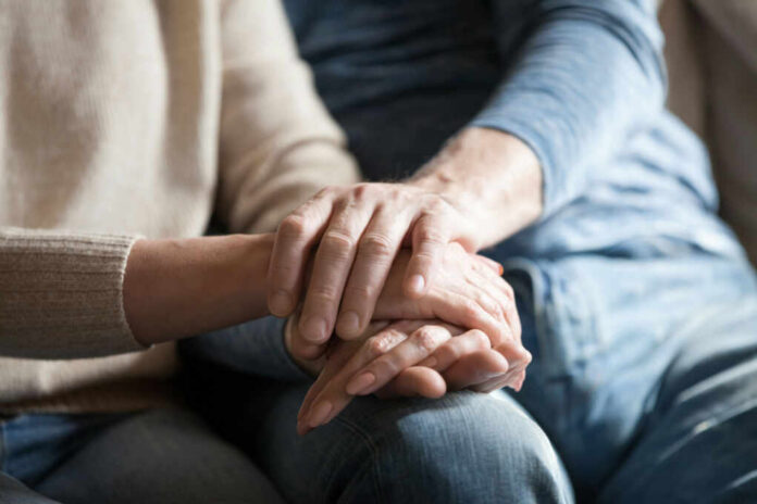 shutterstock_1185179128.jpg Close-up of two hands gently holding each other, symbolizing support and affection