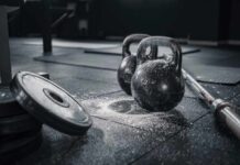 Kettlebells and weights on a gym floor with chalk dust