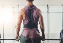 The Overlooked Muscle Growth Hack A muscular person preparing to lift a barbell in a gym setting