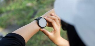 Person adjusting a smartwatch on their wrist outdoors