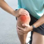 Bone Health Breakthrough: Collagen’s New Role Athlete holding their knee in pain while exercising outdoors