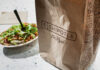 How A Salad Makes You Crave The Cheeseburger and Fries A Chipotle takeout bag next to a bowl filled with fresh salad ingredients