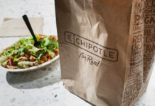 How A Salad Makes You Crave The Cheeseburger and Fries A Chipotle takeout bag next to a bowl filled with fresh salad ingredients