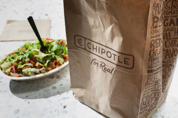 shutterstock2498827385jpg A Chipotle takeout bag next to a bowl filled with fresh salad ingredients