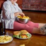 Can You Out-Exercise an Unhealthy Diet? Child sitting on the floor enjoying snacks from a bowl
