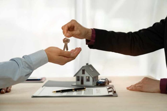 A person handing over house keys during a real estate transaction