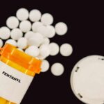 Prescription bottle of fentanyl with white pills scattered around