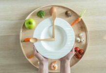 The Foods That Deliver the Most Bone Support Hands holding a white plate surrounded by fresh vegetables and an egg