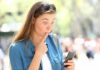 Woman looking surprised at smartphone outdoors