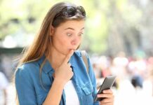Phone Check Every 5 Minutes—Addiction or Choice? Woman looking surprised at smartphone outdoors