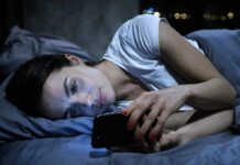 Doomscrolling Epidemic: How To Break Free Woman lying in bed looking at a smartphone