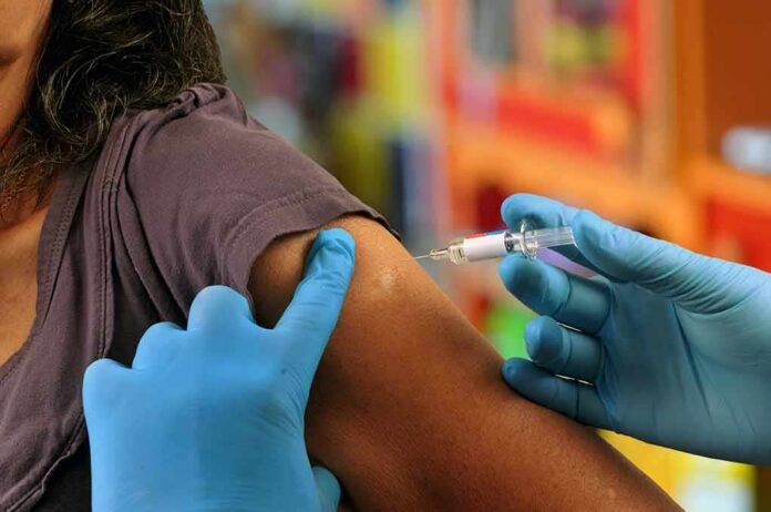 Healthcare worker administering vaccine in upper arm