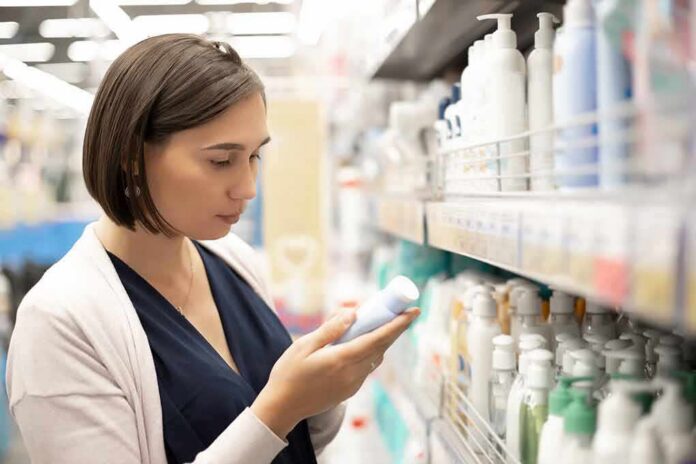 shutterstock_1809401596 Woman shopping for skincare reading a bottle in a store aisle