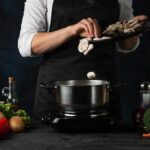 Dinner Staple that Blocks the Spread of Cancer Cook adding sliced mushrooms to a pot