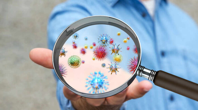 Close,Up,On,A,Sick,Man,Hand,Through,Magnifying,Glass A person holding a magnifying glass showing colorful microorganisms