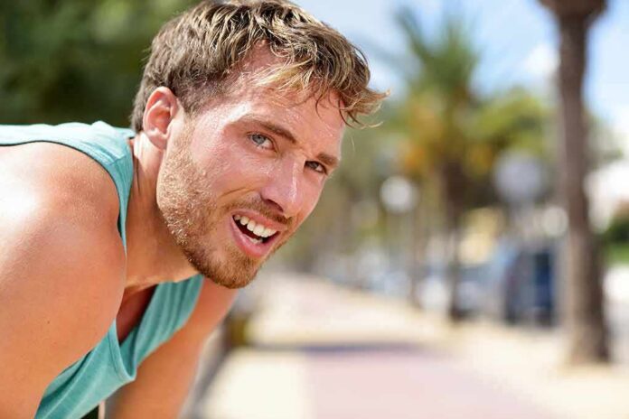 shutterstock_1017406066-2 man in athletic tank top resting outdoors