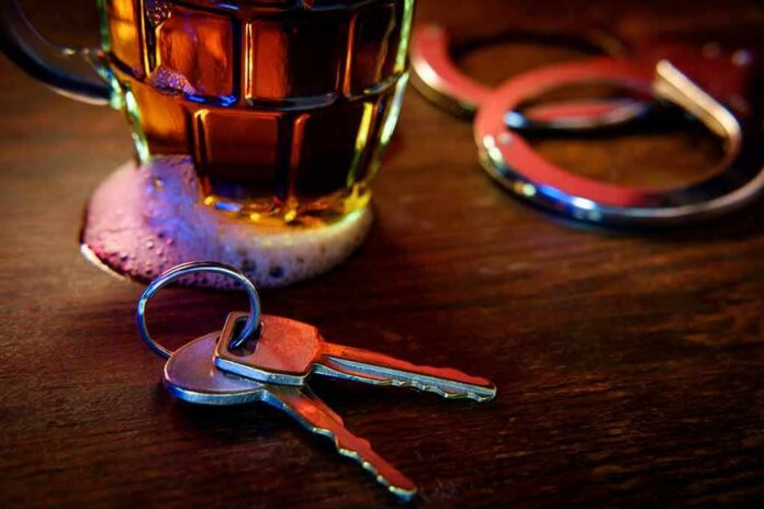 shutterstock_1064996888 House keys on bar beside beer mug and handcuffs