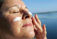 Derm-Backed SPF 50 Serum That Leaves No Whitecast Woman applying sunscreen near water
