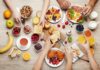 Breakfast table with assorted foods and hands serving