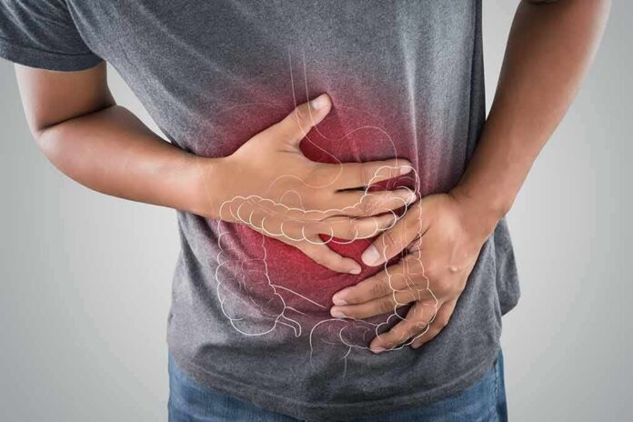 shutterstock_1080392243 Person clutching stomach with colon illustration overlay