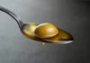 Olive Oil Ritual Sparks Doctor Debate Green olive on a spoon with olive oil