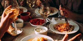 Pasta dinner with wine on a sunlit table