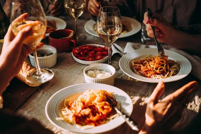 Pasta dinner with wine on a sunlit table