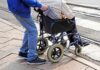 Doctors Sound Alarm On Caregiving Burnout Caregiver pushing person in wheelchair over curb