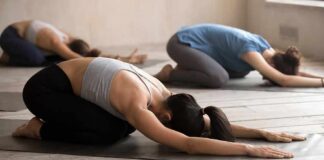 Group of people in child's pose during a yoga class