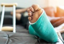 Low D, High Surgery Pain: Surgeons Stunned Injured foot in a turquoise cast resting on a couch
