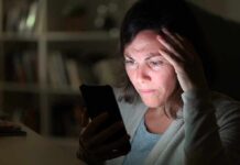 Woman looking at smartphone with worried expression