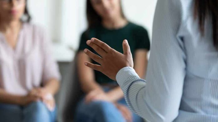 shutterstock_1849647793 Speaker gesturing during a small group discussion