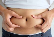 Belly Fat Tied To Humiliating Leaks person pinching belly fat at the waist