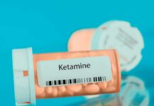 Prescription pill bottle labeled ketamine on a blue background