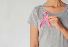 Young Cancer Surge Baffles England Person holding a pink ribbon on a gray shirt