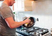 Kitchen Hack SLASHES Hormone Disruptors Man spraying oil into a wok over a gas stove