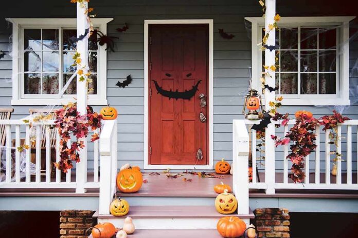 front porch decorated for Halloween with pumpkins and bats
