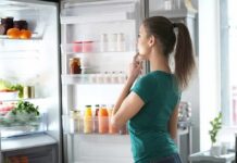 Woman looking into an open refrigerator