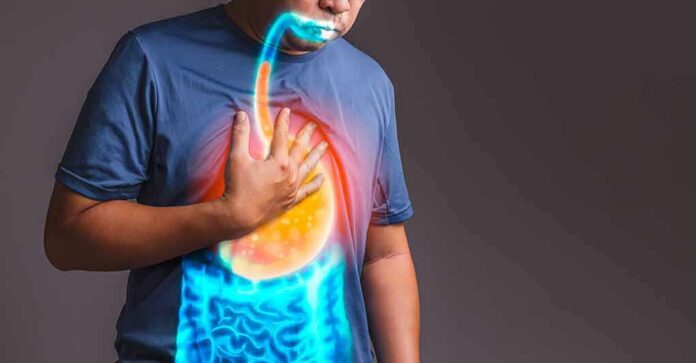 Person clutching chest with illustrated reflux and stomach overlay